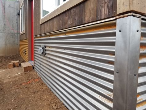 Rusting Corrugated Metal run Horizontally. Little features like drip edge under the siding and covered corners and outlets give the nice clean look. Corrugated Metal Underpinning, Corrugated Metal Skirting, Tin Underpinning Mobile Home, Under House Skirting, Metal Deck Skirting Ideas, Corrugated Metal Siding Exterior, Metal Underpinning Mobile Home, Corrugated Metal Deck Skirting, Tin Underpinning