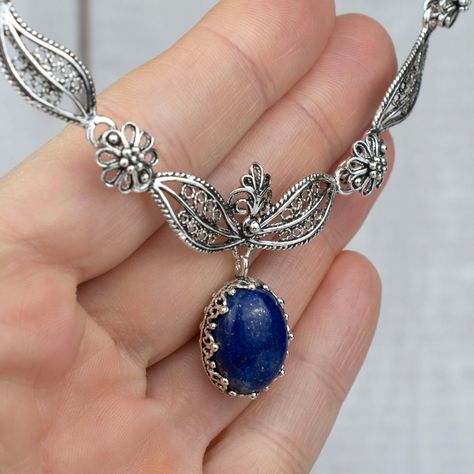 925 Sterling Silver Filigree Art Lapis Lazuli Gemstone Paisley Design Necklace Length is 17.00" and it has a 2.00" extension. It is secured with lobster claw closure. The Lapsi Lazuli gemstone genuine, cabochon cut and dimension is 12X16 mm oval. Lapis Lazuli is a stone that emboldens the communicative abilities between the mind, throat, and heart. One will shortly begin to find themselves radiating the truth of their emotional body. Lapis Lazuli’s energies promote heightened intellect, inner vi Boho Pendant Necklace, Blue Stone Necklace, Floral Pendant Necklace, Lapis Lazuli Jewelry, Princess Necklace, Filigree Necklaces, Filigree Jewelry, Lapis Lazuli Gemstone, Emotional Body