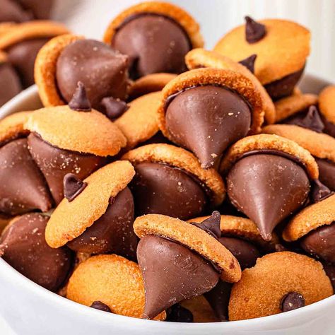 Hershey Kisses acorn treats are adorable bite-sized snacks that combine the classic chocolate kiss with a cookie base to create a whimsical Acorn Candy Kisses, Acorn Snacks Hershey's Kisses, Acorn Treats Kisses, Acorn Cookies Hershey's Kisses, Hershey Kiss Acorns, Thanksgiving Food Crafts For Kids, Thanksgiving Themed Food, Thanksgiving Snack Ideas, Fun Thanksgiving Food