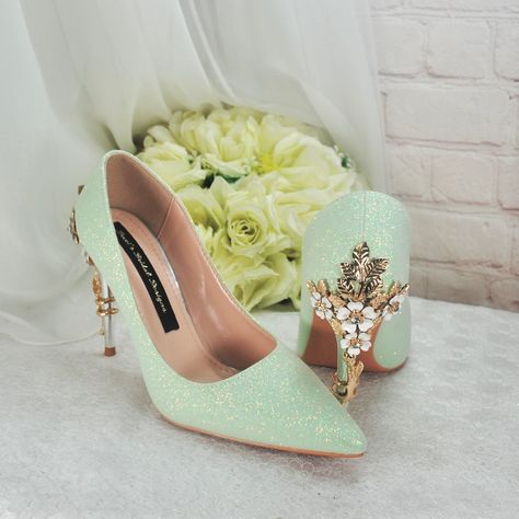 Beautifully handmade satin bridal shoes finished with a stunning glitter finish. These glitter wedding shoes have a metal 'cherry blossom' embellishment on the heels, and are finished with a striking beauty and the beast image on the soles Design Details: * Handmade Satin Bridal Shoes * Comfortable Shoes with cushioned insoles. * Heel height: 9cm  * Colour Availability: Green * Pointed Toe Court Shoe * Handcrafted Cherry Blossom Details on Heels Included with your order: * Handmade shoes with cu Bridal Shoes Comfortable, Glitter Wedding Shoes, Striking Beauty, Flower Heels, Heel Protector, Wedding Shoes Bride, Bridal Wedding Shoes, Shoe Boxes, Glitter Wedding