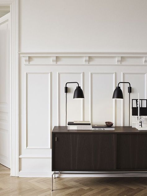 White panelling, herringbone flooring and dark wood sideboard. Perfection. |T.D.C | Cult Design News: Caravaggio Read by Cecilie Manz for Lightyears Interior Design Examples, Interior Minimal, Berlin Design, Minimal Interior Design, 아파트 인테리어, Kitchens And Bedrooms, Wall Molding, Minimalism Interior, Design Del Prodotto