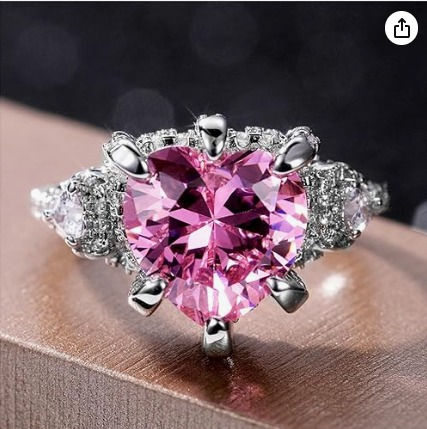 This 925 Sterling Silver ring is a stylish and elegant piece designed for women. It features a heart-shaped pink gemstone surrounded by shimmering cubic zirconia (CZ) diamonds, giving it a radiant, eye-catching sparkle. The ring is crafted from high-quality sterling silver, ensuring durability and a polished, shiny finish. Its design makes it a versatile accessory, perfect for engagements, weddings, or as an eternity band. Ring Heart, Colored Engagement Rings, Trendy Ring, Cz Ring, Pink Ring, Ring Promise, Ring Diamond, Cz Diamond, Color Ring