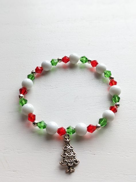 Handmade stretchy beaded Christmas charm bracelets. Perfect to add a little cheer to your holiday outfit. Makes a great gift. Comes with either a red or green assorted mesh gift bag. These ready to ship handmade bracelets are sized at 7 1/2 inches. The perfect gift How to order: Choose your bracelet type from drop down menu. The photo will auto to the type of bracelet. Choose the type you would like to order and check out. How to Measure Your Wrist:  take a flat tape measure and measure around your wrist in inches, where you wear the bracelet. If you want the bracelet to be snug/tight excat inches. If you want it to be a little lose  size up to a half-to full inch. Christmas Stretch Bracelets Ideas, Holiday Bracelet Ideas, Holiday Beaded Bracelets, Beaded Christmas Bracelets, Christmas Beaded Jewelry, Christmas Beaded Bracelets, Christmas Bracelet Ideas, Stocking Stuffers Unique, Holiday Jewelry Ideas