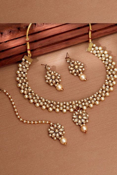 This jewellery set consists of a necklace, a pair of earrings and a maang tikka Gold-plated necklace, has stone-studded and pearl beaded detail Secured with a drawstring closure A pair of matching drop earrings, each secured with post and back closure Gold-plated maang tikka, has stone-studded and pearl beaded detail, secured with hook closure. . . #jewellery #necklase #mang tikka Mang Tikka, Engagement Mehndi Designs, Instagram Jewelry, Maang Tikka, Gold Chain With Pendant, Beaded Jewellery, Gold Fashion Necklace, Jewellery Sets, Gold Earrings Designs