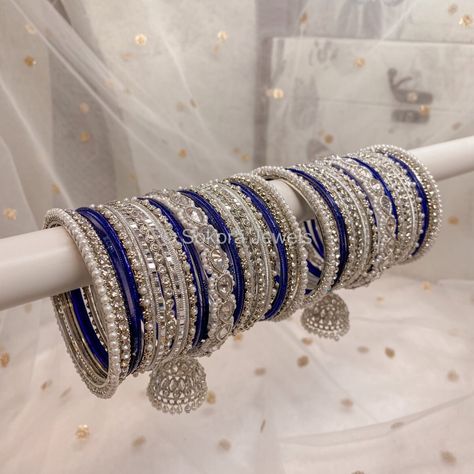 Large stack of luxurious Silver & clear stonework bangles with Navy blue shades finished with our Chunky Silver Husna Jhumka bangles. This will make the perfect stack for any Bride or those wanting to make a statement. Pair this with our Aafiya Bridal Set - Navy Sold as a set for both arms only. Ready to Ship! Navy Blue Bangles Set, Blue Bangles Set, Jhumka Bangles, Bridal Bangle Set, Blue Bangles, Navy Blue Jewelry, Silver Indian Jewelry, Indian Wedding Jewelry Sets, Pretty Jewelry Necklaces