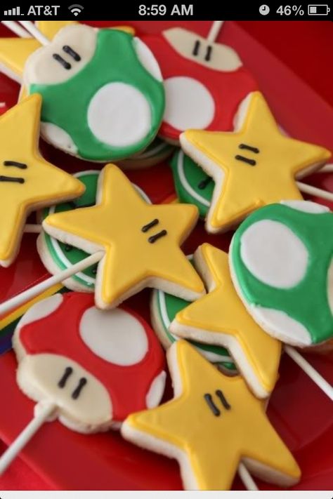 Mario star cookies. Inspired by this picture, I made the star cookies on a stick for my son's classroom birthday party. I used prepackaged refrigerated sugar cookie dough iced with yellow Wilton's candy melts and tiny bit of licorice rope for the eyes. It took forever to make 40 of them, but they did turn out awfully cute. Super Mario Brothers Birthday Party, Bolo Do Mario, Super Mario Bros Party Ideas, Super Mario Brothers Party, Super Mario Brothers Birthday, Mario Brothers Birthday Party, Super Mario Bros Birthday Party, Super Mario Bros Party, Mario Bros Birthday