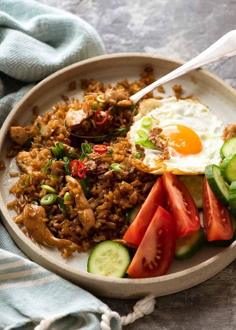 Nasi Goreng on a plate with a side of fried egg, tomato and cucumbers Indonesian Fried Eggs Indonesian Fried Rice Recipe, Nasi Goreng Recept, Nasi Goreng Recipe, Indonesian Fried Rice, Telur Goreng, Egg Tomato, Mojito Recept, Kecap Manis, Cibo Asiatico