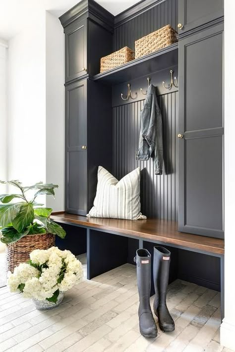 Charming black cottage style mudroom boasts light brick pavers contrasted with a black built-in bench topped with a stained wood seat fixed beneath stacked black locker cabinets adorned with antique brass knobs. Cottage Style Mudroom, Entryway Storage Ideas, تحت الدرج, Mudroom Cabinets, Mud Room Entry, Home Entryway, Mudroom Entryway, Mudroom Decor, Mudroom Laundry Room