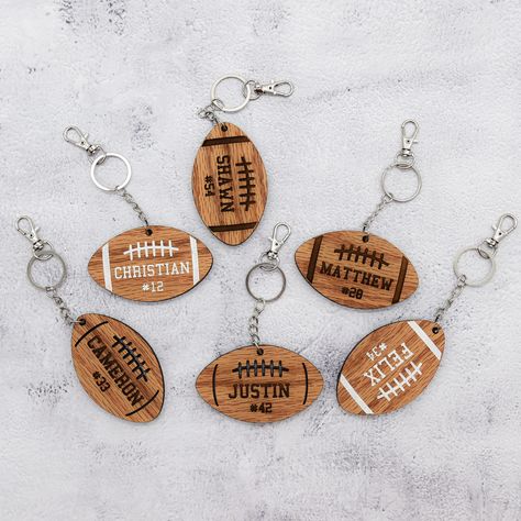 This wood keychain is a wonderful way to add personalization to your football player's bag. Whether it's their school bag or gear bag, let them represent themselves while looking stylish! Perfect for your football superstar! 3 football designs to choose from and you can get either a horizontal or vertical setup. Design A - all engraved Design B - Personalization is engraved and the design is laser cut Design C - engraved then painted white. The back has no design but is stained as well. Perfect School Bag Keychain, Football Bag Tags, Football Locker Decorations, Football Bags, Forge Projects, Football Team Gifts, Woman Costumes, Football Basket, Football Bag