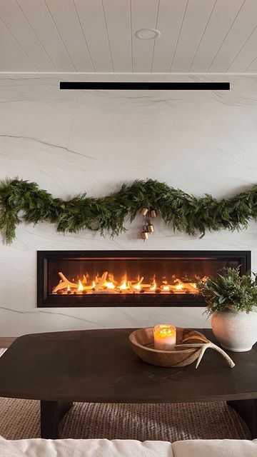 Jennifer Virkus on Instagram: "No Mantle, No Problem! (Comment SHOP for links) Command hooks to the rescue! I used a combination of different hooks and bundle cords to create a “no mantle” fireplace garland moment at the lake house. WHAT I USED: I used 2 (6ft) cedar garlands on each side for a total of 4 garland strands. I stacked them on one another to create a fuller look and secured them with bundle cords and smaller hooks. In true Jenny fashion I just added bells and called it good. For me personally, less is always more 🤍 My garland and bells are from McGee & Co . MHH10 saves you 10% on your order of $100 or more 🤍 HOW TO SHOP- Comment SHOP or tap the link in my Bio to shop my home via the LTK app #fireplacedecor #christmasmantle #modernfireplace" Garland On Electric Fireplace, Garland With No Mantel, Garland On Fireplace Without Mantle, Garland No Mantle, Christmas Fireplace Without Mantle, Christmas Fireplace No Mantle, Fireplace With No Mantle Christmas, No Mantle Fireplace Decor Christmas, No Mantle Christmas Decor