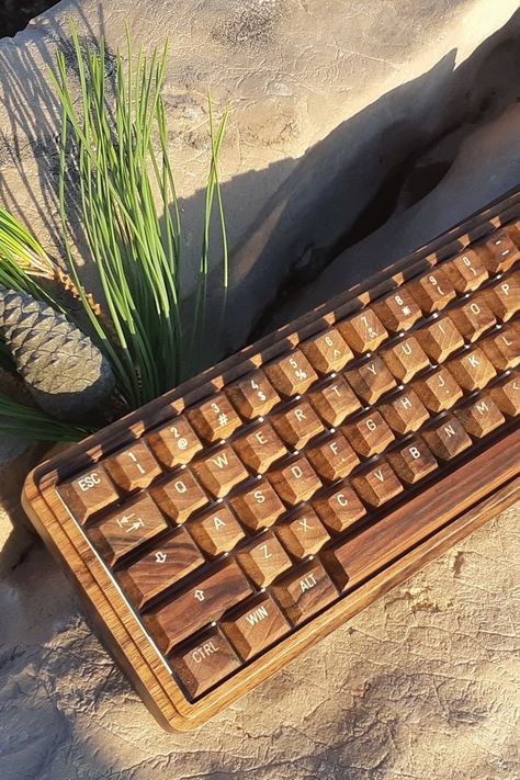 The Handmade Wooden Keyboard is the perfect way to show your love for nature. With its minimal design and rich natural wood grain, this mechanical keyboard is a pleasure to use. The dark walnut wood colors add a touch of excitement to your personal computing space! It's made from solid walnut wood. Each part of the keyboard is hand sanded and coated with an ecological oil that gives it durability while maintaining its natural appearance and feel. Wooden Keyboard, Walnut Wood Color, Love For Nature, Desktop Setup, Key Caps, Wrist Rest, Desk Setup, Mechanical Keyboard, Dark Walnut