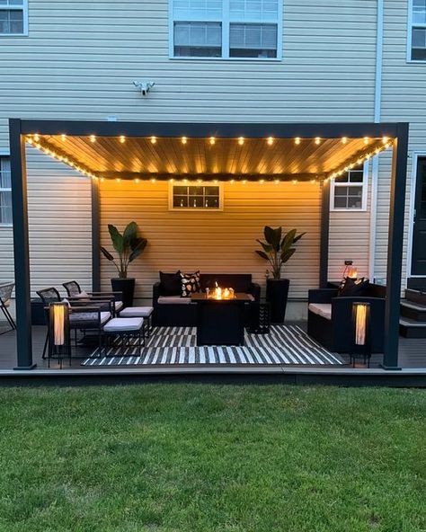 Donice (Dah-neece) on Instagram: "Home lately 🖤  It’s cozy, summer nights on the patio season 🖤  Louvered Pergola @miradoroutdoor  Indoor/outdoor rug @jonathany_official  String lights @jonathany_official   #patio #patioseason #pationights #patiolights #patiodesign #pergoladesign #louveredpergola #louveredroof #louveredpergolas #patiorugs #patiorug #blackpatio #blackpatiodecor #patiostringlights #pergolas #patioinspo #patioinspiration #patioliving #patiolife #modernpatio" Pergola Patio With Lights, Pergola Lights String Ideas, Decks With Pergola Ideas, Corner Patio Ideas, Pergola Decorating Ideas, Cozy Backyard Ideas, Patio Lights String Ideas, Patio Pergola Ideas, Patio Shade Ideas