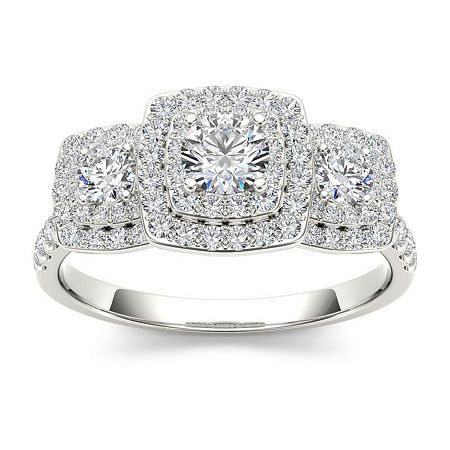 The three-stone setting with halos surrounding each stone creates a stunning combination that will give timeless sparkle and shine to this 1 ct. t.w. 10K white gold engagement ring.Metal: 10K white goldStones: 1 ct. t.w. round diamondsColor: IClarity: I2-I3Setting: Prong, paveGallery Height: 6.7mmCare: Wipe CleanCountry of Origin: ImportedDiamond total weights may vary between .01 and .08 carat.Jewelry photos are enlarged to show detail. Disclaimer: Metal may be rhodium plated to enhance appeara 1 Ct Engagement Ring, Gold Engagement Ring Diamond, Engagement Ring Color, Morganite Engagement Ring Set, Pink Morganite Engagement Ring, Engagement Wedding Ring Sets, White Gold Engagement Ring, Diamond Anniversary Rings, Pink Morganite