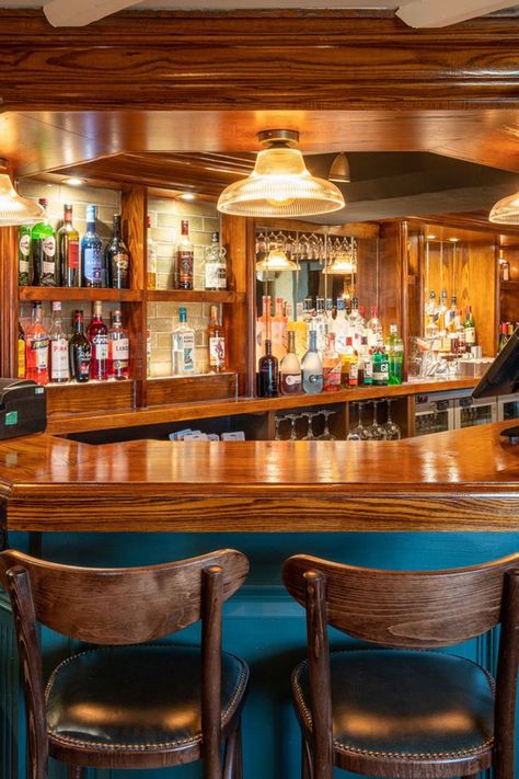 wooden polished bar front, alcoholic bottles out on display in shelves, blue bar front, wooden stools with back. Cosy Bedrooms, Rustic Beams, Ladies Toilet, Diy Home Bar, Pub Chairs, Chairs And Tables, Back Bar, Banquette Seating, The Pub