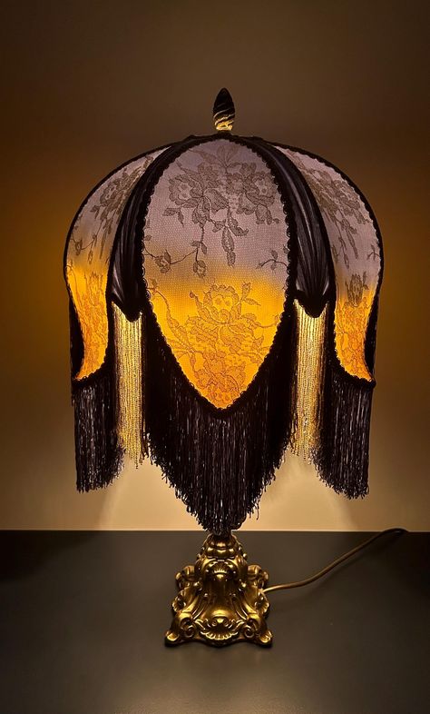 Golden Dawn This exquisite lampshade is handmade and unique. Created using layers of custom dyed silk and topped with Solstiss Lace (as used in the Princess of Wales wedding dress) and sun burst pleats, this stunning lampshade truly is a show stopper! The custom dyed fringe is complimented with golden glass beads and finished off with antique French trim. This shade has an uno fitter, this sits on a harp which is easily fitted to most lamp bases. Dimensions (approximate) Height plus fringe 16.5 Antique Lamp Shades Vintage Lampshades, Victorian Floor Lamp, Antique Lampshade, Princess Lamp, Dyed Fringe, Fringe Lamp, Lampshade Vintage, Victorian Lamp, Wales Wedding