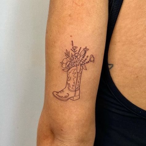 Flower In Boot Tattoo, Fine Line Boot Tattoo, Strong And Devine Tattoo, Minimalist Cowgirl Tattoo, Cowboy Boot With Flowers Tattoo Simple, Western Boot Tattoos For Women, Fine Line Cowgirl Boot Tattoo, Cowboy Boot With Wildflowers Tattoo, Cowgirl Boot Flower Tattoo