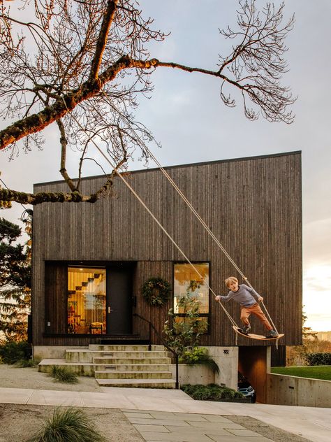 Exterior, Shed RoofLine, House Building Type, and Wood Siding Material Architect Michael Leckie riffed on a rhombus shape for Jennifer Warner and  Cara Frey’s new home. Their son, William, 6, swings in front of the cedar-clad house, which sits on the edge of a ridge with views of both hills and downtown.  Photo 1 of 25 in A Darkened Cedar Dwelling in Portland Embodies “Less But Better” Design Portland Architecture, Less But Better, Dwell Magazine, 1920s House, Beach Shack, Cool House Designs, Prefab Homes, Algarve, Great View