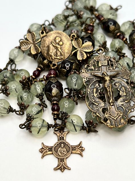 FIVE DECADE ROSARY FEATURING Mater Dei (Mother of God) with Shamrocks solid bronze Vintage Replica Centerpiece - The shamrock is used as a metaphor for the Holy Trinity.   * 10mm Garnet Pater Beads * 8mm Prehnite (Stone of Prophecy) Ave Maria Beads * Brass Leaf Embossed Bead Caps  * 2" Vintage Replica Bronze Crucifix with two Angels * 1" Mater Dei solid bronze Vintage Replica Center * Half-Hard Durable, Tarnish Resistant * Length 29" Each bead is individually wire wrapped and should never come a Blue Rosary, Decade Rosary, Mother Of God, Prayer Bracelet, Catholic Rosary, Rosary Catholic, Catholic Gifts, Holy Trinity, Mother Mary