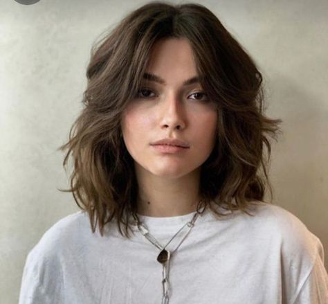 Embrace your natural texture and rock this effortlessly chic style that flatters a variety of face shapes. This layered, shoulder-length cut features face-framing pieces that add movement and dimension. Click here to see more stunning hairstyles for women over 60 with fine hair. Short Haircut For Wavy Hair Mid Length Round Faces, Square Layered Haircut, Julia Stiles Short Hair, Middle Part Collar Bone Length Hair, Midlength Hairstyles For Fine Hair, Short Haircuts Middle Part, Medium Hair 2024 Trends Women, Shoulder Length Hair Cuts With Layers For Wavy Hair Medium, Medium Hair With Long Layers