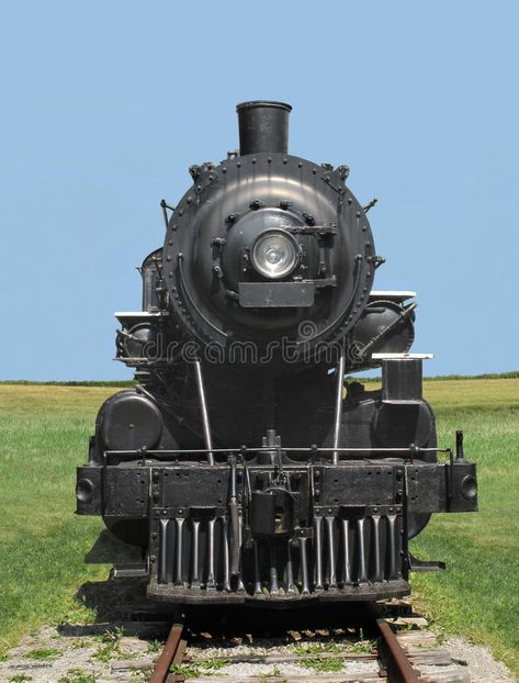 Photo about Front view of a vintage black railroad train steam locomotive, on tracks in a field with a clear blue sky in the background. Image of engine, retro, locomotive - 27206938