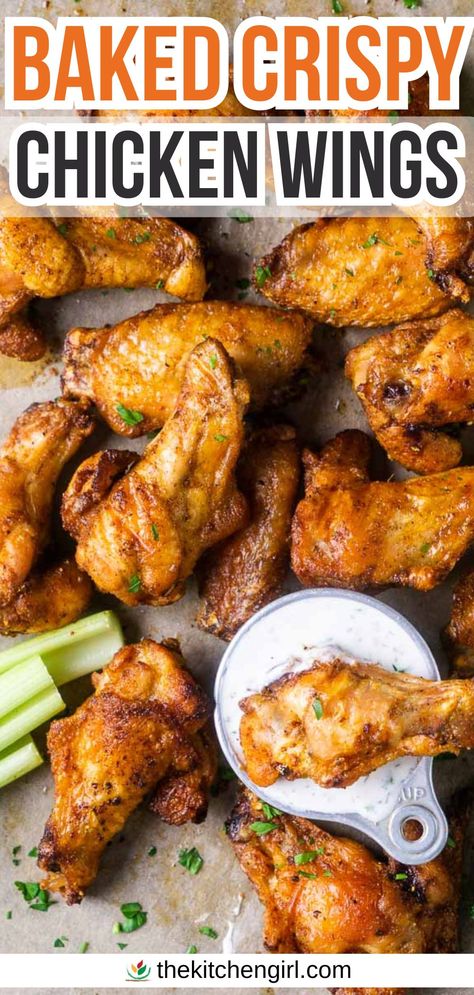 image of crispy baked chicken wing dipping into ranch dressing next to pile of wings and celery sticks on parchment paper. Title text: Baked Crispy Chicken Wings Healthy Baked Wings Oven, How To Make Wings Crispy In Oven, Baked Chicken Party Wings Recipes, Baked Chicken Wings Oven Easy, Asian Wings Recipe Oven Baked, Baked Crispy Wings, Oven Fried Chicken Wings Baking Soda, Bone In Chicken Wings Oven Baked, Slow Baked Chicken Wings