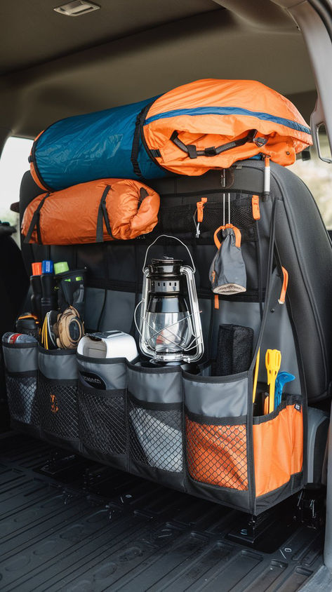 Back-of-seat organizer filled with camping gear, including sleeping bags, a lantern, and various outdoor essentials, neatly arranged in a truck for efficient space management. Truck Camping Hacks, Pick Up Truck Camping, Truck Camping Setup, Car Camping Ideas, 4runner Camping, Car Camping Hacks, Car Camping Organization, Gear Organization, Pickup Trucks Camping