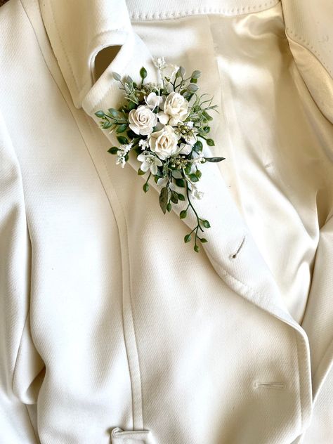 Wedding lapel corsage in a pretty array of Ivory roses with mixed foliage.  Secures to your lapel or fabric bag with a safety pin at the back. Approx 3 wide x 5 inches long Mother Of The Bride Corsage Pin, Foliage Boutonniere, Unique Corsage, Corsage Wedding Mother, Lapel Corsage, Pin On Corsage, Mother Of Bride Corsage, Shoulder Corsage, Wedding Wrist Corsage