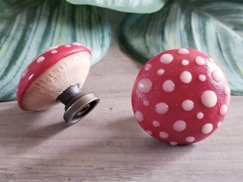 "Enchant your cabinets & drawers with the magic of mushrooms. Hand sculpted from durable, eco-friendly & non-toxic clay, each mushroom is modeled around an antiqued metal knob. Sealed with a triple thick satin glaze to ensure long lasting beauty for years to come. Includes 1\" screws. Size: 1.5\" W x 1.5\" D Just like the real thing, each mushroom is unique and size, shape & spots may vary." Mushroom Astethic Room, Cute Door Knobs, Funky Door Knobs, Witchcore Home Decor, Mushroom Themed Bathroom, Mushroom Kitchen Decor Ideas, Mushroom Dresser, Mushroom Diys, Mushroom Cabinets