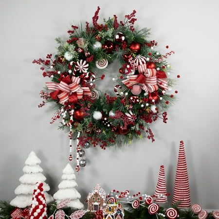 This delightful wreath brings the sweetness of the holiday season right to your doorstep. Unlit and pre-decorated with an array of red and white striped bows, vibrant ornaments, luscious berries, peppermint garland, and faux candies, it's a whimsical treat for the eyes. Whether you hang it on your front door or display it indoors, this peppermint Christmas wreath will instantly transform any space into a festive wonderland. Product Features: Unlit. Two-tone green mixed pine and frosted foliage . Peppermint Garland, Peppermint Wreath, Pine Christmas Wreath, Metal Foam, Candy Wreath, Peppermint Christmas, Christmas Decorations Wreaths, Peppermint Candy, Tree Ideas