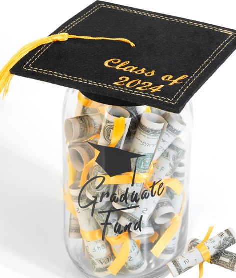 PRICES MAY VARY. What better way to congratulate a graduate than with a mason jar filled with money? The package includes: 1 mason jar with lid, 1 felt graduation cap, 40 clear rubber bands, and 40 gold ribbon strips. The mason jar measures 6.8 inches x 2.9 inches, and the glass bottle features the printed text "Graduate Fund". Easy to assemble - roll the bills up and tie them with the included rubber bands and ribbons before placing into the jar. Finish with the Class of 2024 cap lid. This is t Graduation Mason Jars, Graduation Centerpieces, Diy Graduation Gifts, 8th Grade Graduation, Graduation Money, Diy Graduation, Candy Party Favors, Money Holder, Graduation Diy