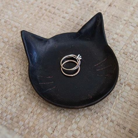 The Black Cat Tray is a shallow black resin tray in the shape of a cat face. The tray is made complete with subtle distressed details and whisker indents. This tray makes a great gift and can be used to hold jewelry, keys, or other small trinkets. Measures 1" high by 4" long by 3.75" wide. Cat Clay Tray, Black Cat Pottery, Jewelry Dish Clay, Clay Jewelry Tray, Cat Ashtray, Trinkets Dish, Cat Trinket Dish, Black Clay Pottery, Ceramics Cat