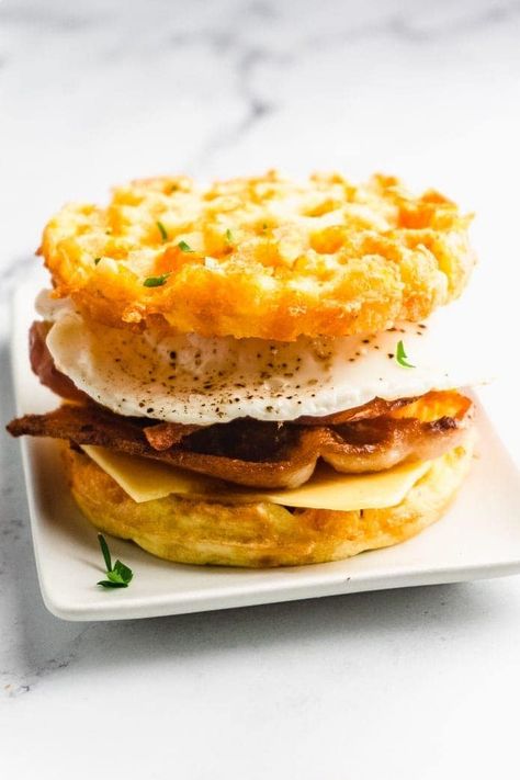 Try this recipe for a keto breakfast sandwich made with crispy bacon, egg, and cheesy chaffles! This recipe is low in carbs and high in flavor.  It's so quick and easy to make -- perfect for busy mornings. Chaffle Breakfast, Keto Breakfast Sandwich, Sandwich With Bacon, Keto Chaffle, Keto Zucchini, Bread Alternatives, Carb Alternatives, Egg Sandwiches, Low Carb Breakfast Recipes