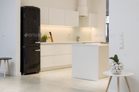 White kitchen with black fridge by bialasiewicz. Minimalistic kitchen interior with white furniture and a black modernist fridge#fridge, #bialasiewicz, #black, #White Expensive Fridge, Kitchen With Black Fridge, Luxurious Minimalism, Modern Konyhatervezés, Black Fridge, Minimalistic Kitchen, Black Fridges, Black Appliances Kitchen, Kitchen Design Black