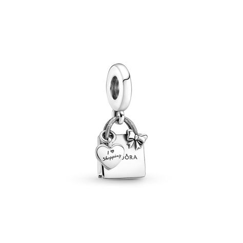 Wear a playful nod to your love of shopping with the PANDORA Shopping Bag Dangle Charm. This heart bag charm is hand-finished in sterling silver, features an engraved PANDORA logo on the front and back, plus a delicate bow detail on the front. A separate dangling heart-shaped bag tag includes the engraved message. This charm is ideal for you if you adore shopping and are looking for a sleek, polished silver addition to your look.   Grace & Co have been authorised PANDORA UK retailers for ove Pandora Shopping Bag Charm, Pandora Shopping Charm, Pandora Silver Charms, Pandora Shopping Bag, Pandora Chain Bracelet, Silver Pandora Charms, Pandora Bracelet Designs, Pandora Logo, Pandora Bag