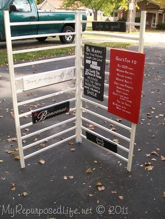 Crib Repurposed into Sign Display Piece. But I want to use it as a drying rack and linen display rack.  Looks like the two sides are attached with utility zip ties through holes at each end. Repurposed Crib, Craft Fair Booth Display, Craft Show Booths, Craft Show Booth, Craft Booth Display, Quilt Display, Craft Fairs Booth, Fair Display, Craft Booth Displays