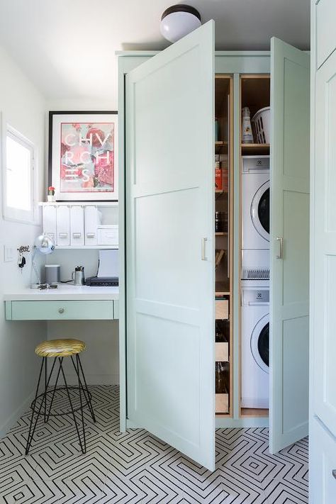 A stacked white front loading washer and dryer is hidden in floor-to-ceiling mint-green cabinets. Hidden Door In Laundry Room, Laundry Hidden In Kitchen, Hidden Washer And Dryer In Kitchen, Outdoor Washer And Dryer Ideas, Tall Cabinet Doors, Hidden Laundry Rooms, Laundry Cabinet, Green Cabinet, Hidden Laundry