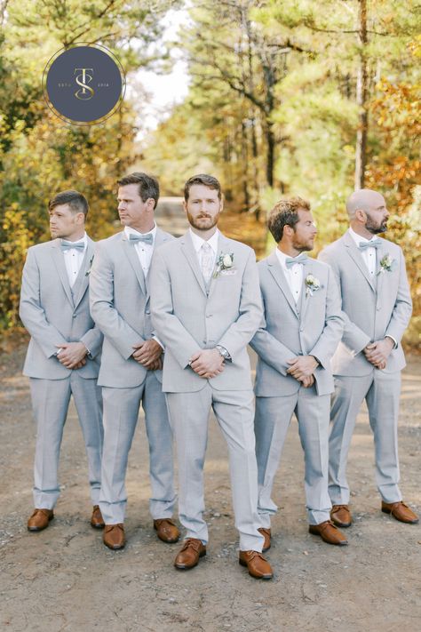 Soft gray suits for this December wedding. The groom stands out with a light gray tie while groomsmen don traditional bowties in light blue matching the bridesmaid dresses. All are wearing matching brown shoes. #graysuits #groomsmeningray #graysuitforgroom #sainteterrewedding #groomstyle #weddingdaysuits #groomsmeninspo #weddingparty Light Blue Groomsmen Suits, Light Gray Groomsmen, Light Grey Suits Wedding, Dark Grey Groomsmen, Groomsmen Attire Grey, Light Gray Suit, Light Gray Wedding, Gray Groomsmen Suits, Private Vows