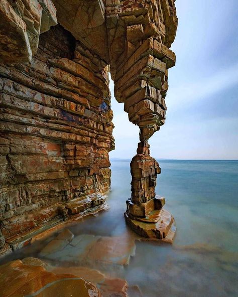 Would you like to go see this rock formation? "In a small secluded rocky beach approximately 120 Km from Dalian there is this beautiful rock formation called "Table Leg Rock". There is a small "catch" to go there: you have to walk along the beach beside a steep cliff at low tide to reach this place. When we went there it was around 330 p.m. Then you have to wait until the tide rises up to the feet of the rock to get a nice foreground of the stones covered by the sea and this happened around 6 p Matka Natura, Table Leg, Natural Rock, Rock Formations, Bhutan, Amazing Places, A Rock, Mountain Landscape, Tibet