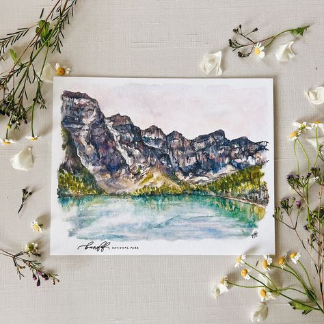 "Banff National Park - Alberta Canada,  Fine Art Watercolor Print featuring the turquoise glacier water of Moraine Lake, pines, and the scenery of the Rocky Mountain Range.  Lovely print made from original watercolor painting celebrating Banff National Park. Perfect for National Park and travel lovers, or to add to a gallery wall. Popular for nurseries and baby shower gifts. Available in 4 different sizes on lovely smooth matte or textured paper. Features delicate \"Banff National Park\" in mono Watercolor Paintings Nature, Mountains Travel, Wedding Numbers, Painting Nature, Moraine Lake, Botanical Art Prints, 2023 Christmas, Park Art, Gallery Wall Art