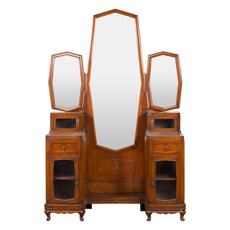 An Indonesian vintage ladies' dressing table from the mid 20th century, with three mirrors and marble accents. Created in Indonesia during the midcentury period, this dressing table features a central octagonal Psyche mirror with beveled glass flanked with two smaller folding ones. The ensemble showcases drawers and small cabinets, the latter topped with marble insets. Accented with a raised veneered cartouche and raised on petite cabriole legs, this vintage Indonesian dressing table will be an Vintage Vanity Table, Vanity Table Vintage, Vintage Dressing Table, Indonesian Furniture, Mirrored Vanity Table, Vintage Dressing Tables, Antique Cabinets, Large Bathrooms, Cabriole Legs