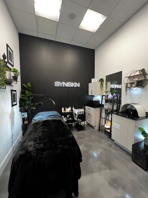 Black accent wall in esthetician room. Lit up sign that says synskn. Green plants accent the room. Marble grey floors and two white walls. Solo Esthetician Room, Esthetician Studio, Solo Esthetician, Front Yard Flower Bed, Spa Room Ideas, Waxing Room, Facial Room, Tech Room, Lash Room Decor