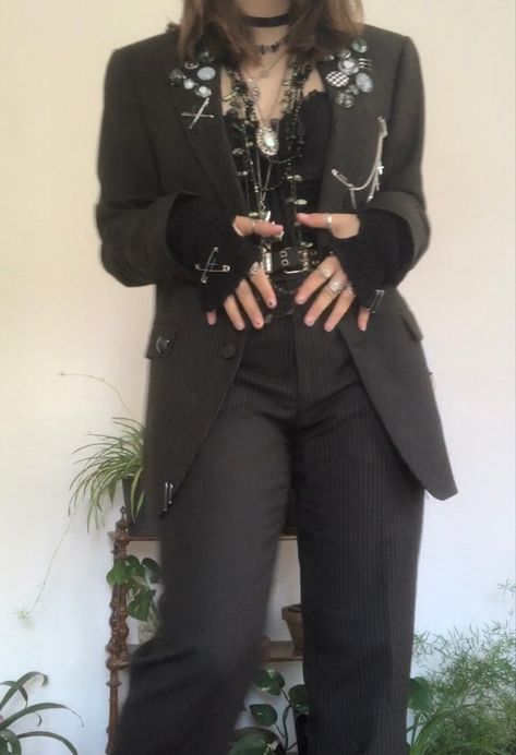 A mid-sized person/girl grey/dark green striped suit decorated with lots of oins and chains, black arm warmers, black platform dr. Martens and multiple crystal rings and bracelets. 		The person is also wearing multiple silver necklaces, a big one in form of a cross. Alternative Semi Formal, Aesthetic Suit Outfit, Alt Suit Outfit, Punk Blazer Outfit, Alt Suit Aesthetic, Punk Prom Suit, Masc Goth Outfits Formal, Punk Corset Outfit, Alternative Formal Wear