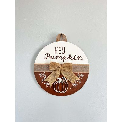 Our line of seasonal door hangers are the perfect touch of farmhouse and rustic décor. Embellished with a 1-1/2” wide natural burlap ribbon across the center with a matching bow, this sign is UV printed with a charming design. It can be hung on a door or wall with the matching burlap ribbon hanger. The pumpkin is a wood cutout attached to give a 3D effect to the design. This decorative door sign is are available in both 10” and 14” diameters. They are a great way to welcome your family, friends Winter Wooden Door Hangers, Seasonal Door Hangers, Hey Pumpkin, Wooden Door Signs, Fall Stuff, Fall Door Hangers, Family Fun Night, Wood Door Hangers, Front Door Signs