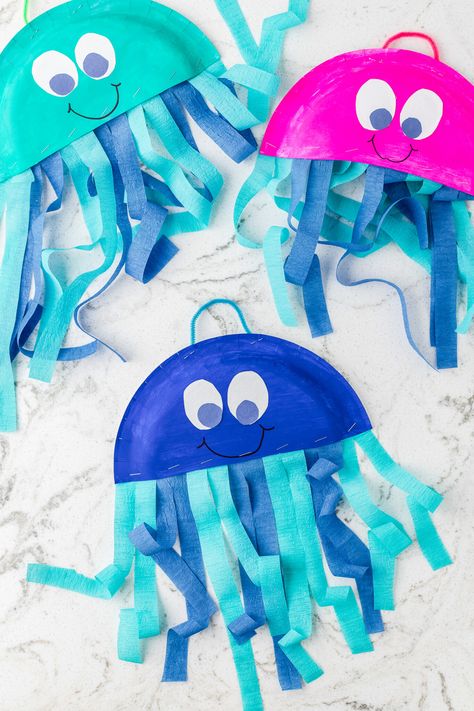 Bright, cute Jellyfish created out of a paper plate are an easy kids craft that they will love making. Grab your craft supplies and create this easy paper plate craft. Not only will the kids love making this jellyfish craft, but they will brighten up your house when they display them. Easy May Crafts For Kids, Toddler Spring Crafts Easy, Rainbow Fish Paper Plate Craft, Star Fish Craft For Toddlers, Jellyfish Paper Plate, Paper Plate Spring Crafts, Jelly Fish Art And Craft, Jellyfish Art And Craft, Birds And Fish Creation Craft