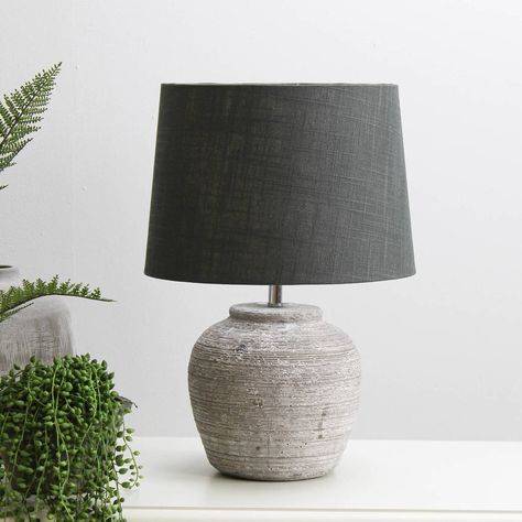 Grey Stone Effect Table Lamp With Shade This table lamp is the perfect size light for your bedside table. Accompanied with a 100% linen shade, this is ideal for a home interior looking for a natural and grey earthenware effect look.  We recommend using a B22/40W bulb for that pefrect balance of light. Bulb not included. Resin and iron  100% linen shadeHeight 44 x Shade dia 30 cm Side Table Lamp, Round Table Lamp, Rattan Baskets, Table Lamps Living Room, Cosy Room, Grey Table Lamps, Side Table Lamps, Luxurious Home, Grey Table