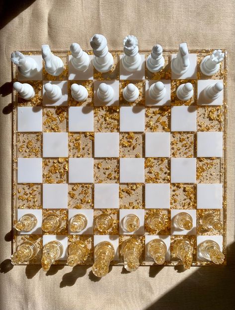 This exquisite handmade custom-made resin chess set is the perfect blend of artistic craftsmanship and timeless strategy for chess enthusiasts and collectors alike. Each piece is meticulously handcrafted from premium quality resin, ensuring a durable, yet elegant finish. These shimmering metallic flakes imbue each piece with a touch of opulence, creating a mesmerizing visual experience as you engage in the age-old game of kings. This one-of-a-kind chess set is not only a functional game board bu Fancy Chess Board, Resin Ideas For Men, Chess Resin, Resin Games, Resin Chess Board, Resin Chess Set, Kings Game, Games Board, Resin Tutorial