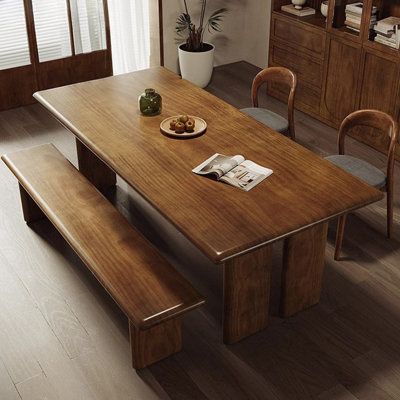 This dining table brings clean lines and a rustic aesthetic to your eat-in kitchen or dining room. It is made of solid wood with a brown finish that accentuates the natural grain of the wood. Size: 29.53" H x 55.12" L x 27.56" W | Wildon Home® Eleeza Dining Set 29.53 H x 27.56 W x 55.12 D in brown / greenWood in Dark Brown | 29.53" H x 55.12" L x 27.56" W | Wayfair Long Wooden Kitchen Table, Solid Wood Dining Table Design, Live Edge Table And Bench, Dark Dining Table Light Chairs, Bench Dinner Table, Cottage Dining Room Table, Natural Wood Table Dining, Kitchen Table With Bench Seating, Dining Room Table With Bench