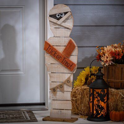 This rustic pine wood mummy is an inviting Halloween statue that will look great wherever it is placed. He proclaims 'Trick or Treat' and has a 'Boo' banner. | The Twillery Co.® Painted Wood Halloween Mummy Figurine Wood in Brown | 32 H x 9 W x 4 D in | Wayfair Wood Halloween, Fall Wood Crafts, Hallowen Ideas, Halloween Wood Crafts, Halloween Crafts Decorations, Halloween Mummy, Pallet Crafts, Fall Halloween Crafts, Halloween Porch