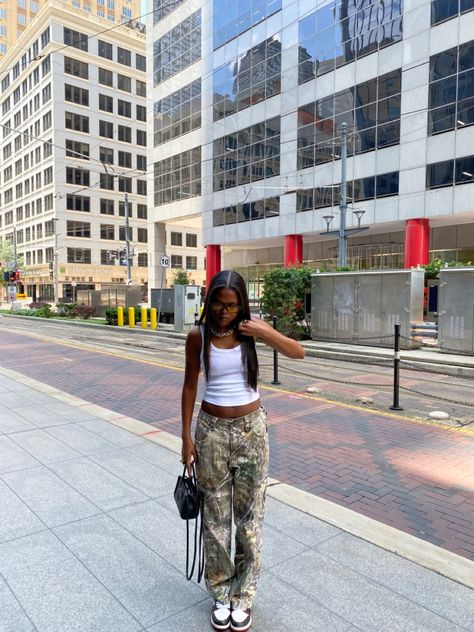 90s Camo Pants Outfit, Oversized Camo Pants Outfit, Camuflage Outfit Pants, Green Camo Pants Outfits, Camp Cargo Pants Outfit, Green Telfar Bag Outfit, Real Tree Camo Pants Outfit, Camo Pants Outfit Black Women, Camo Pants Outfit Women