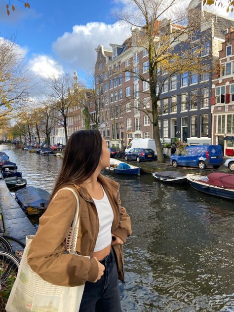 girl in amsterdam standing by canal, streetwear outfit, brown jacket, tote bag, claw clip, canal houses Amsterdam Aesthetic Pictures, Germany Instagram Pictures, Netherlands Photo Ideas, Amsterdam Pictures Ideas, Amsterdam Instagram Pictures, Amsterdam Outfit Summer, Amsterdam Aesthetic Outfit, Amsterdam Photo Ideas, Amsterdam Pictures